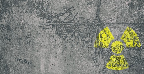 Image of Yellow radioactive sign on grey textured background, banner design. Radiological pollution