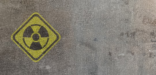 Image of Yellow radioactive sign on textured background, banner design. Radiological pollution