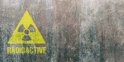 Image of Yellow radioactive sign on textured background, banner design. Radiological pollution