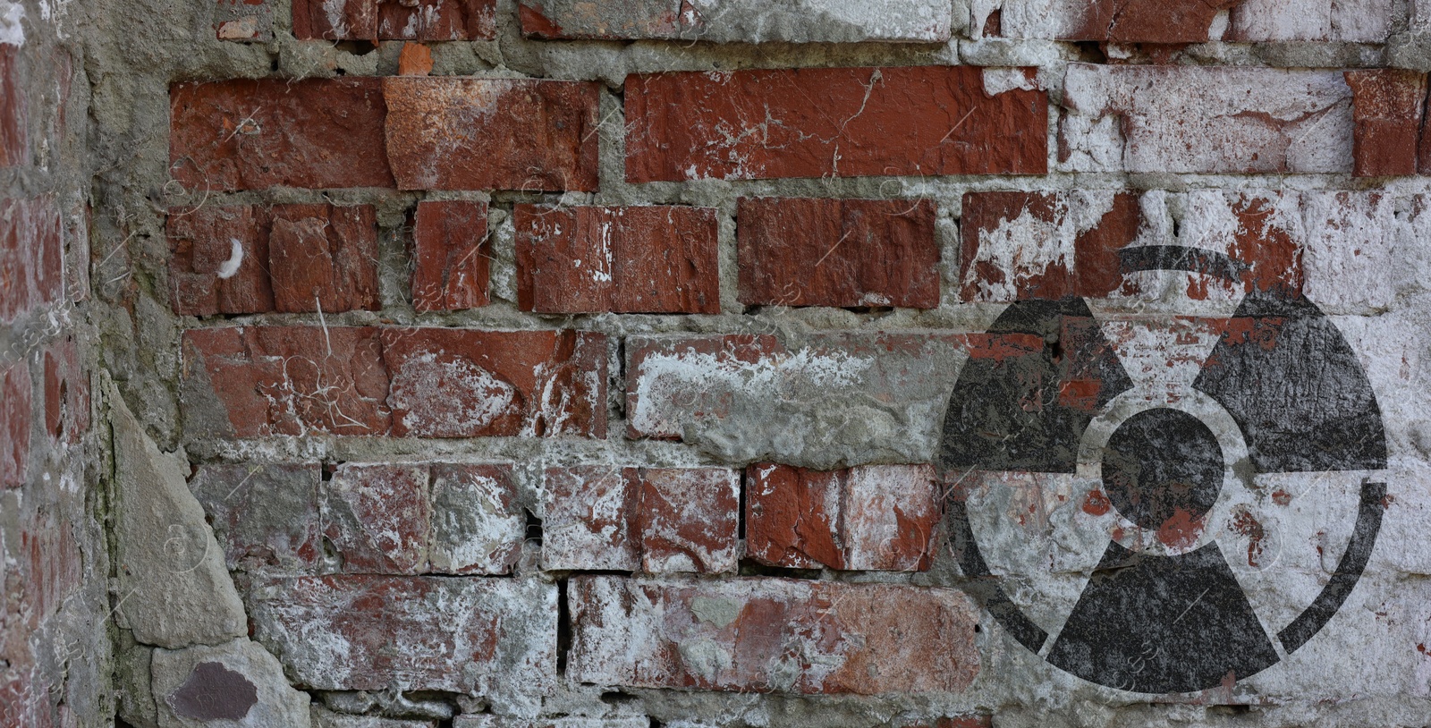 Image of Black radioactive sign on old brick wall, banner design. Radiological pollution