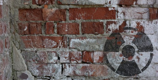 Image of Black radioactive sign on old brick wall, banner design. Radiological pollution