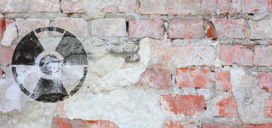 Image of Black radioactive sign on old brick wall, banner design. Radiological pollution
