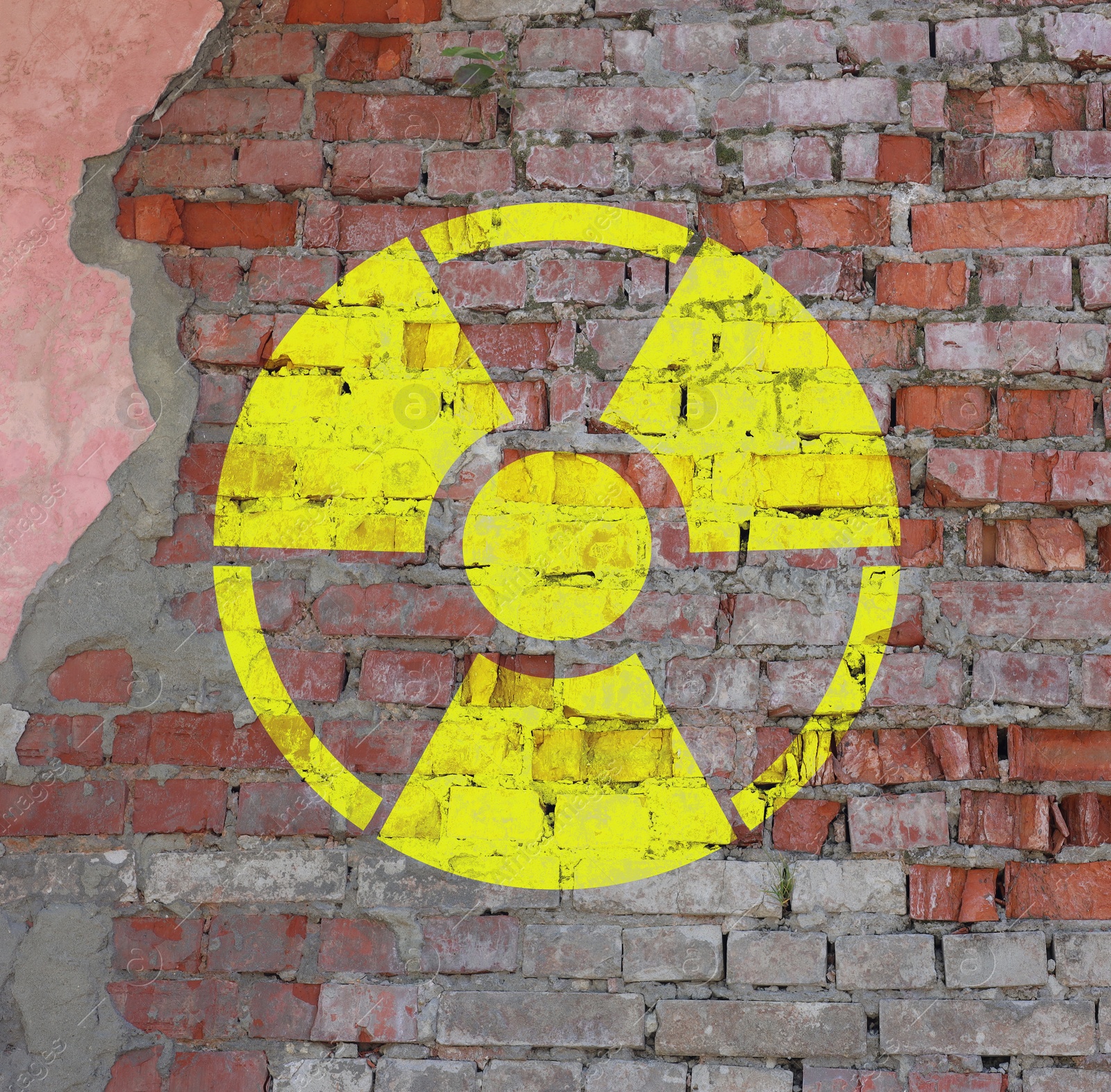 Image of Yellow radioactive sign on old brick wall. Radiological pollution