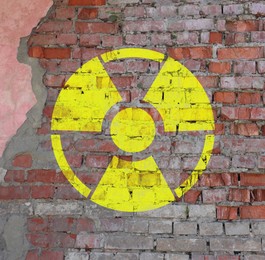 Image of Yellow radioactive sign on old brick wall. Radiological pollution