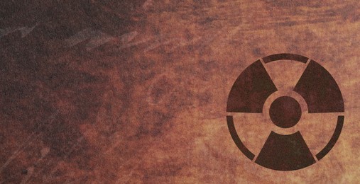 Image of Black radioactive sign on brown textured background, banner design. Radiological pollution
