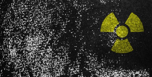 Image of Yellow radioactive sign on black textured background, banner design. Radiological pollution