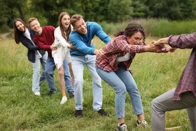 Photo of Team building. Group of happy people holding hands outdoors
