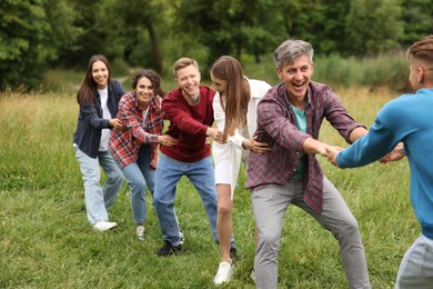 Photo of Team building. Group of happy people holding hands outdoors
