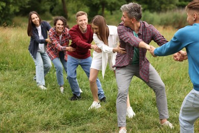 Photo of Team building. Group of happy people holding hands outdoors