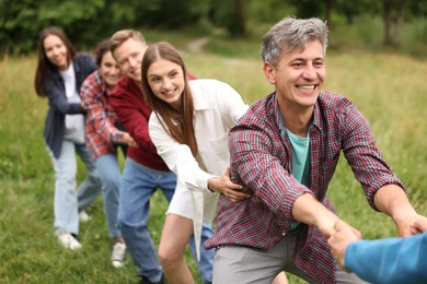 Photo of Team building. Group of happy people holding hands outdoors