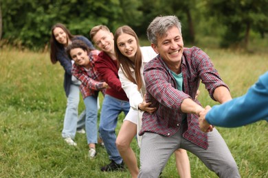 Photo of Team building. Group of happy people holding hands outdoors