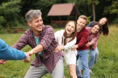 Photo of Team building. Group of happy people holding hands outdoors