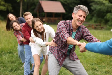 Photo of Team building. Group of happy people holding hands outdoors