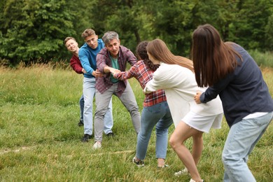 Photo of Team building. Group of happy people holding hands outdoors