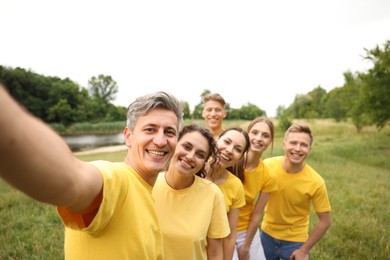 Photo of Team building. Group of happy people taking selfie outdoors