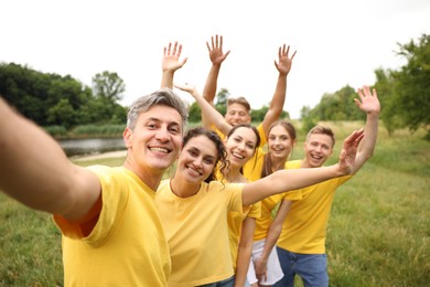 Photo of Team building. Group of happy people taking selfie outdoors