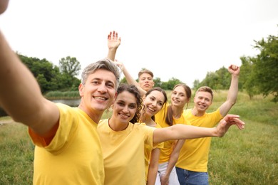 Photo of Team building. Group of happy people taking selfie outdoors
