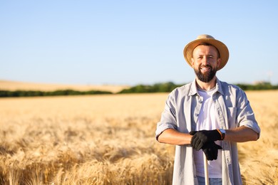 Photo of Farmer in field with ripe wheat outdoors, space for text
