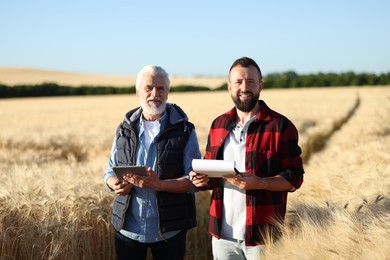 Photo of Farmers in field with ripe wheat outdoors