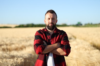 Photo of Farmer in field with ripe wheat outdoors