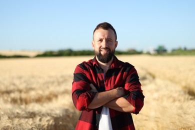 Photo of Farmer in field with ripe wheat outdoors