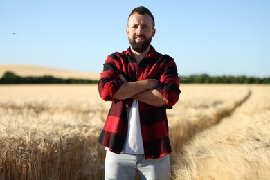 Photo of Farmer in field with ripe wheat outdoors