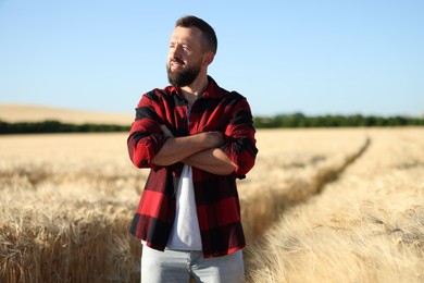 Photo of Farmer in field with ripe wheat outdoors