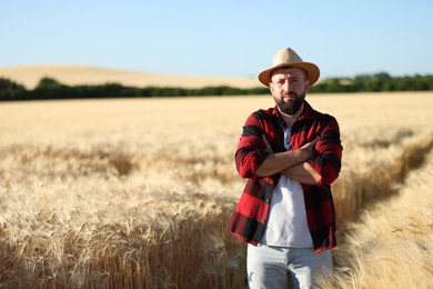 Photo of Farmer in field with ripe wheat outdoors, space for text