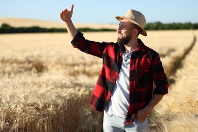 Photo of Farmer in field with ripe wheat outdoors