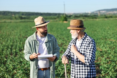 Photo of Farmers in field of unripe soy outdoors
