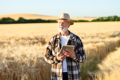 Photo of Senior farmer with tablet in field of ripe wheat outdoors