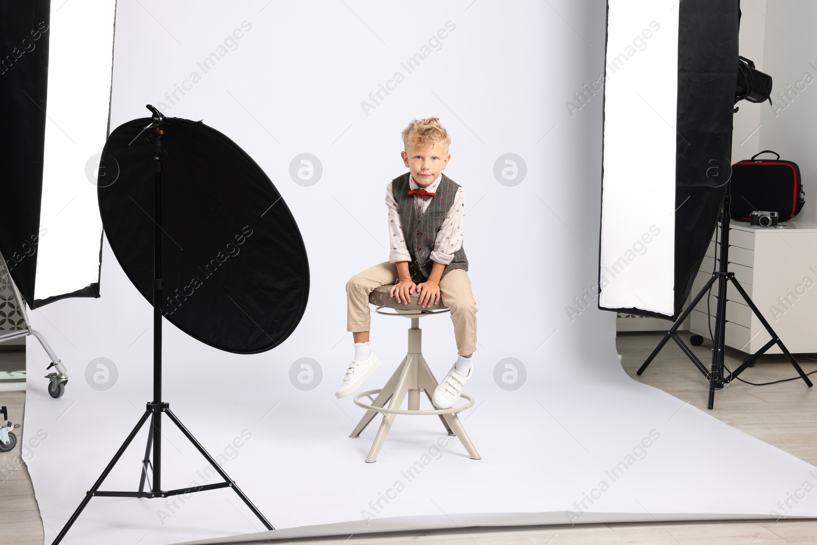 Little boy on white background in photo studio with professional equipment Photo of Little boy on white background in photo studio with professional equipment