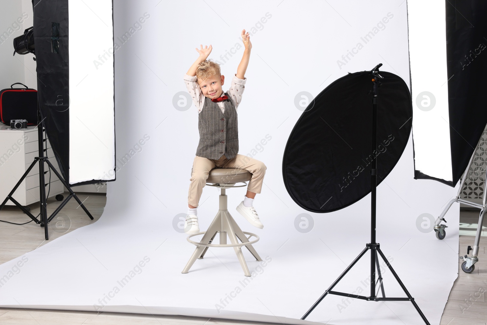 Little boy on white background in photo studio with professional equipment Photo of Little boy on white background in photo studio with professional equipment