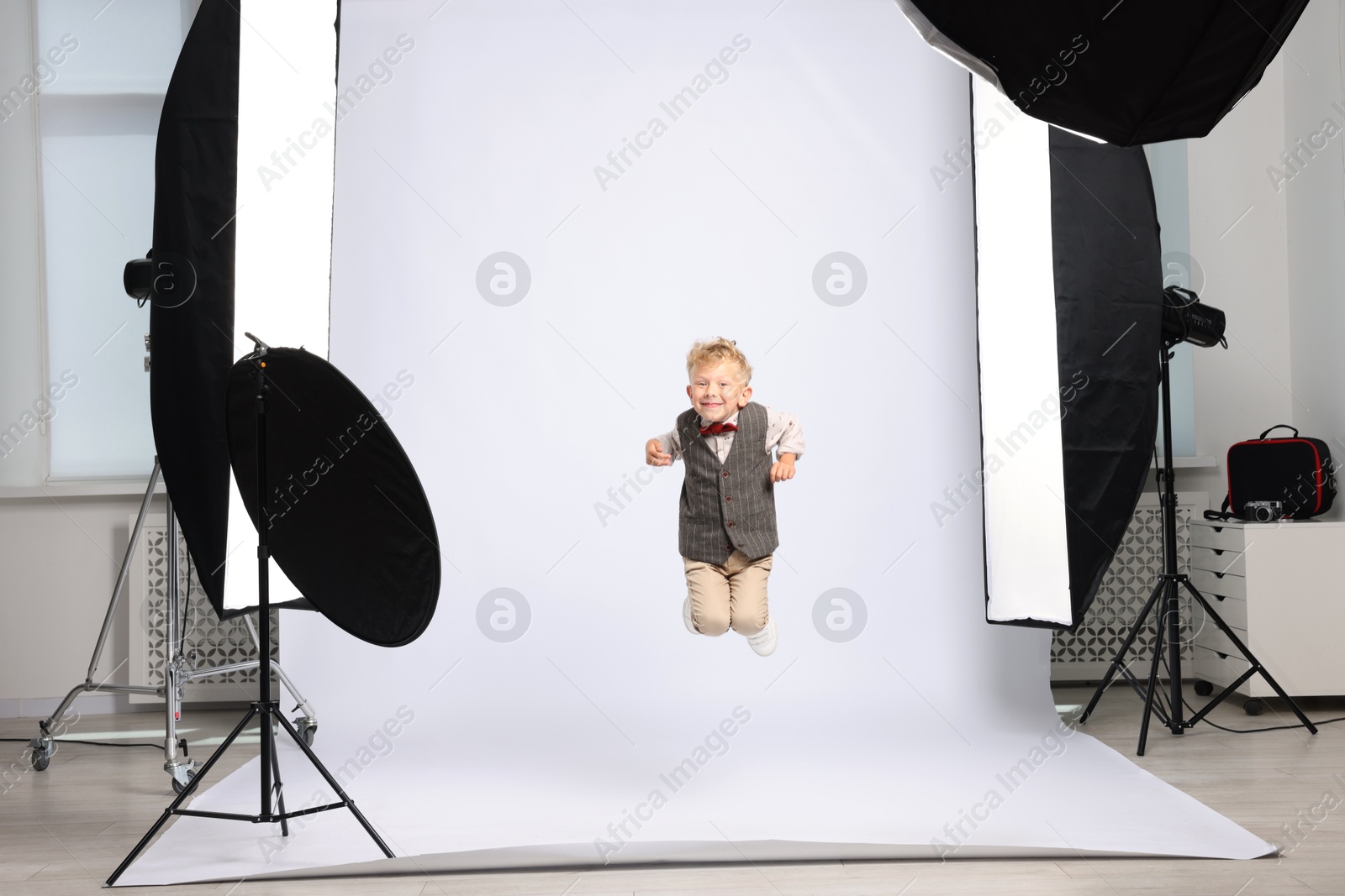 Little boy on white background in photo studio with professional equipment Photo of Little boy on white background in photo studio with professional equipment