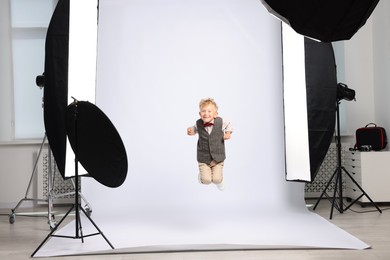 Photo of Little boy on white background in photo studio with professional equipment
