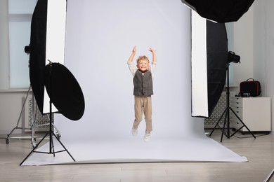 Photo of Little boy on white background in photo studio with professional equipment