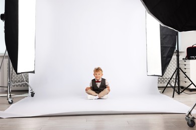 Photo of Little boy on white background in photo studio with professional equipment
