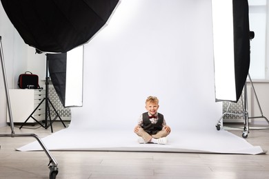Photo of Little boy on white background in photo studio with professional equipment