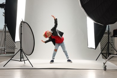 Photo of Little boy on light grey background in photo studio with professional equipment