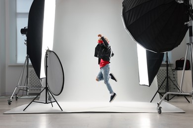 Photo of Little boy on light grey background in photo studio with professional equipment