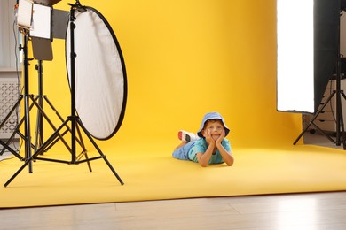 Photo of Little boy on yellow background in photo studio with professional equipment