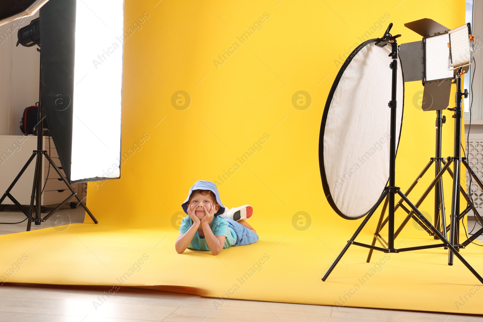 Photo of Little boy on yellow background in photo studio with professional equipment