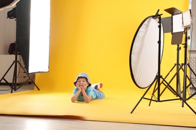 Photo of Little boy on yellow background in photo studio with professional equipment