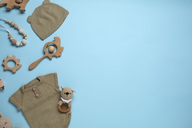 Photo of Cute baby clothes and accessories on light blue background, flat lay. Space for text