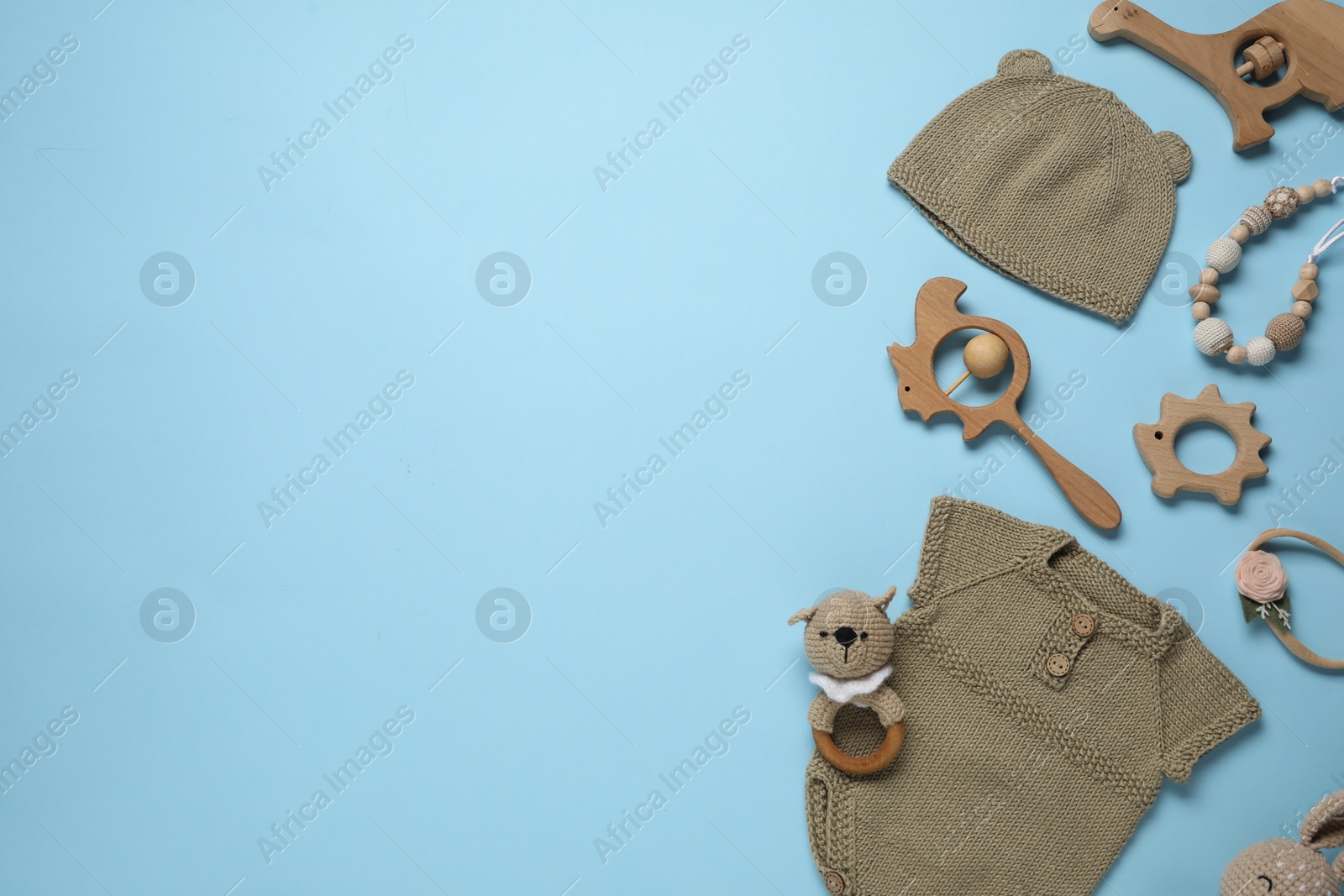 Photo of Cute baby clothes and accessories on light blue background, flat lay. Space for text