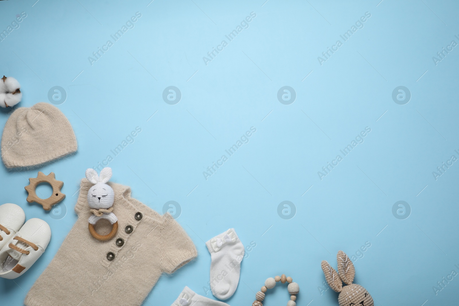 Photo of Cute baby clothes and accessories on light blue background, flat lay. Space for text