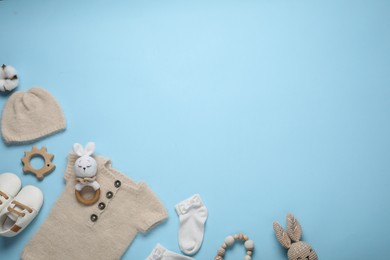 Photo of Cute baby clothes and accessories on light blue background, flat lay. Space for text