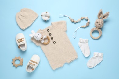 Photo of Cute baby clothes and accessories on light blue background, flat lay