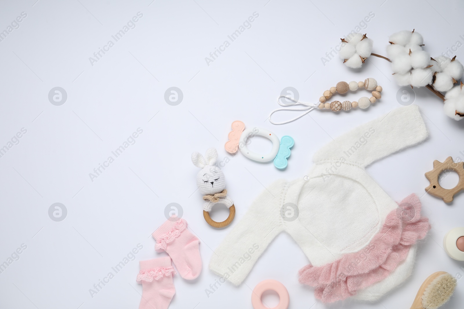 Cute baby clothes, accessories and cotton flowers on white background, flat lay. Space for text Photo of Cute baby clothes, accessories and cotton flowers on white background, flat lay. Space for text