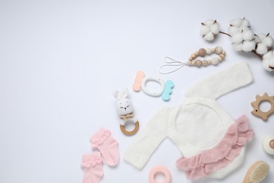 Photo of Cute baby clothes, accessories and cotton flowers on white background, flat lay. Space for text